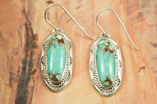 Genuine Number 8 Mine Turquoise Stones set in Sterling Silver French Wire Earrings. The Number 8 mine is located in Eureka County Nevada. Since 1976 there has been no Number 8 Turquoise mined. There is however, an existing stock pile that Mr. Dowell Ward, the last owner of the Number 8 mine, had stocked away for later sorting. The Turquoise is a collector's item--because once the reserve is gone there will be no more material released onto the market. The Gold Mining Company owns the claim to the Number 8 mine and it has been swallowed up by the gold mining operations. This is some of the last Number 8 Turquoise to be had and will be a great addition to your collection. Created by Navajo Artist B.J. Piaso. Signed by the artist.